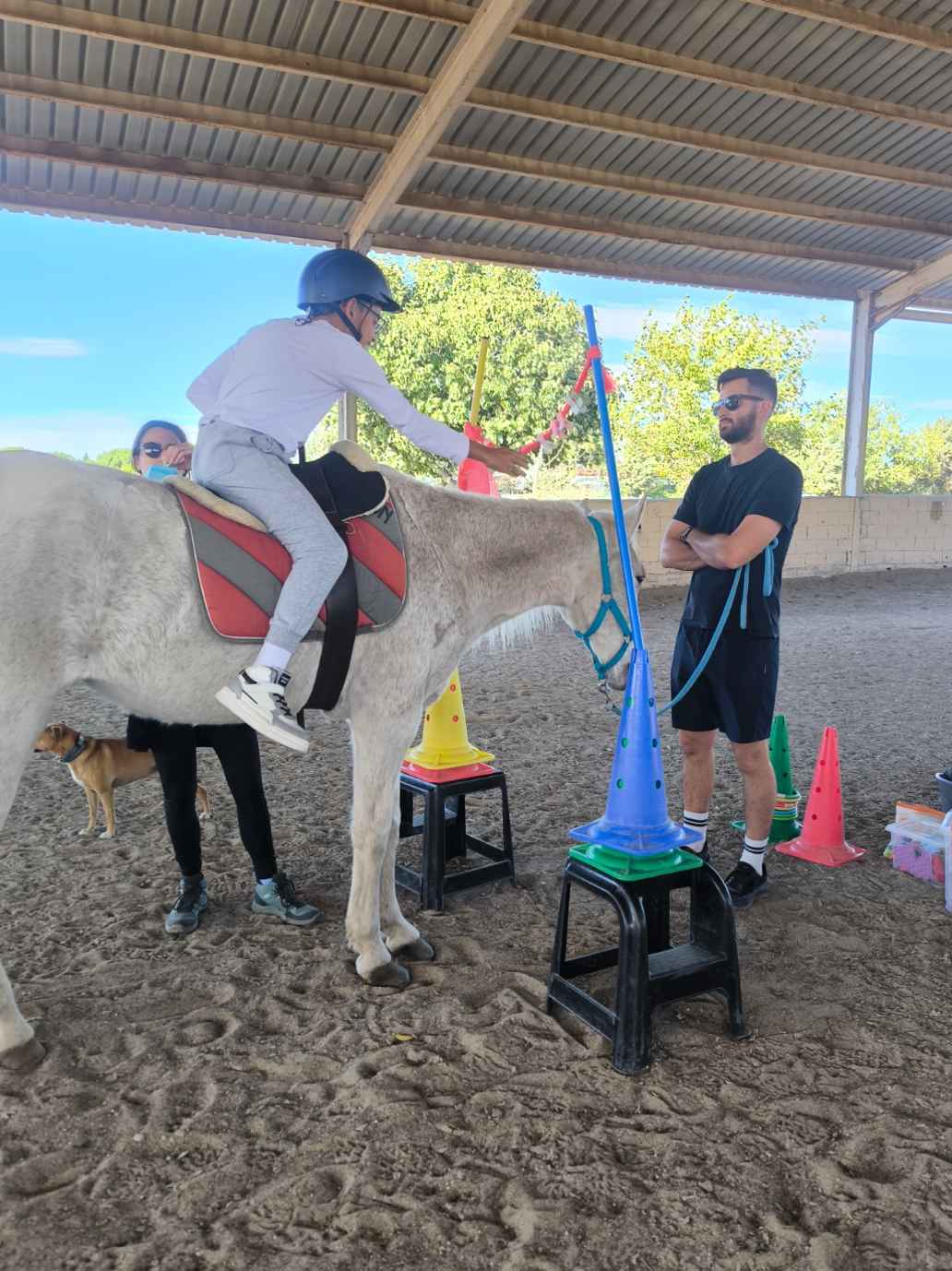 Un monitor frente a un pequeño subido a un caballo